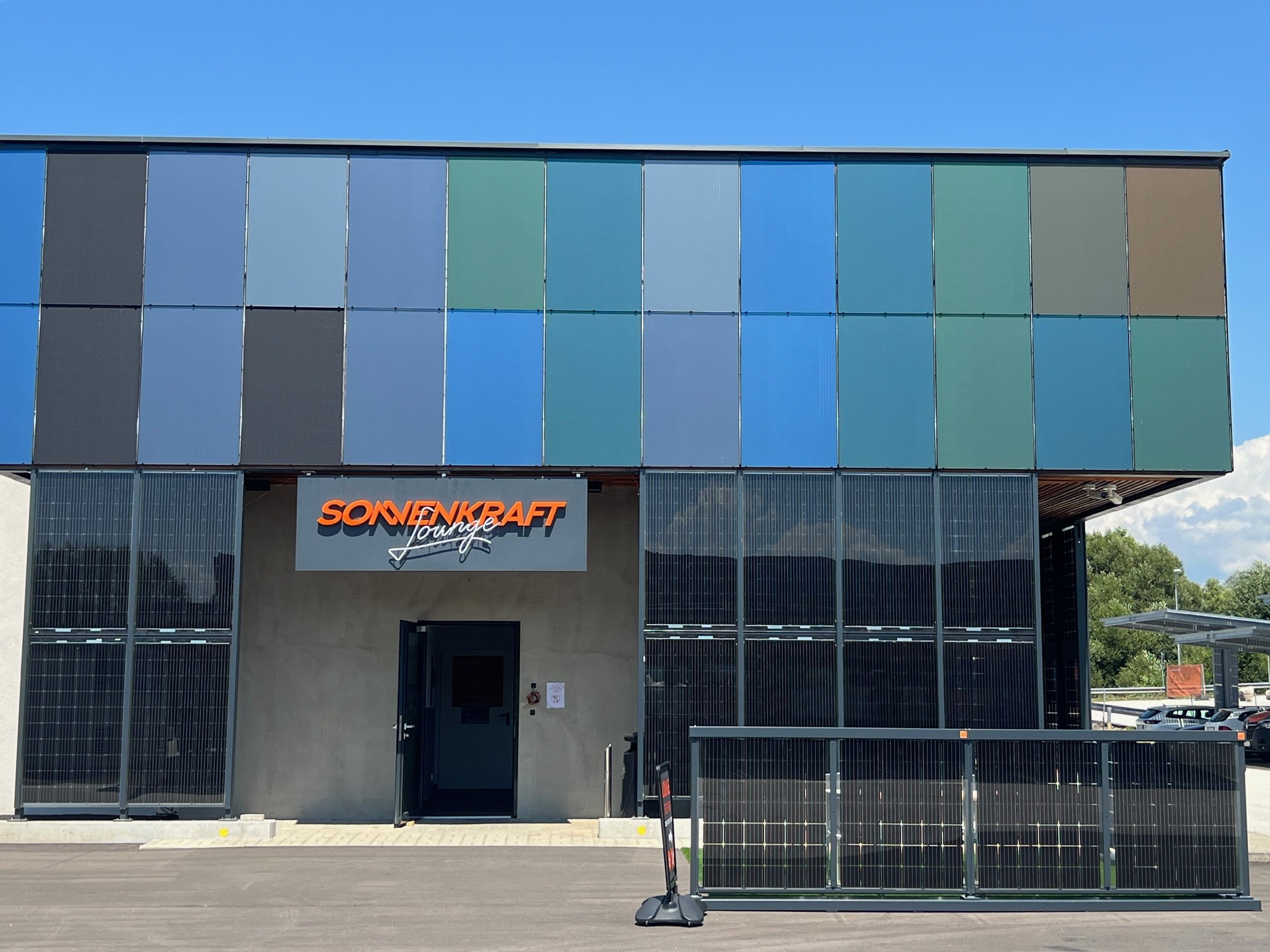 Sonnenkraft Lounge building with colorful solar panels on the facade.