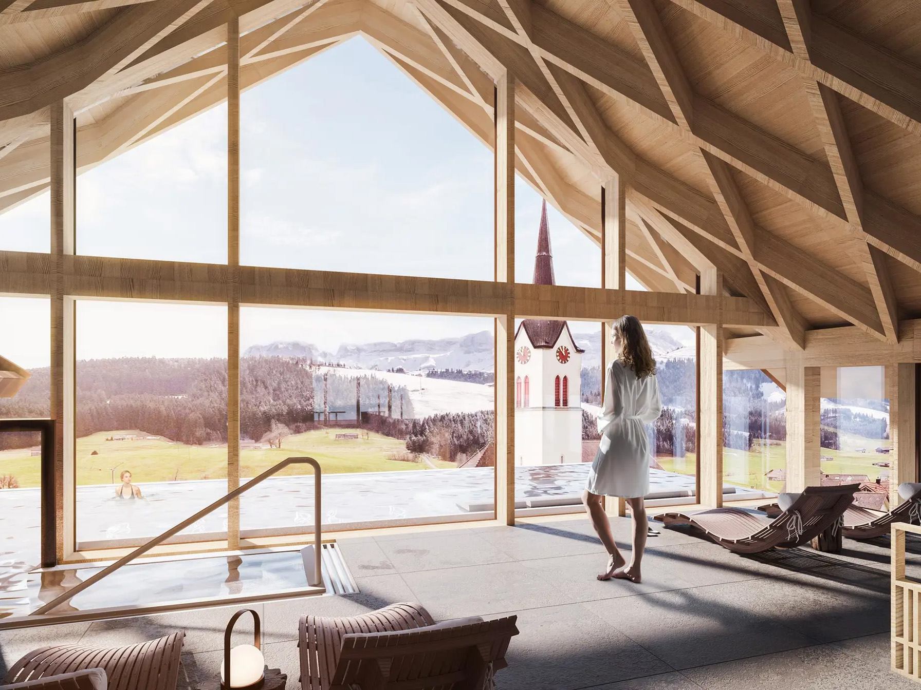 A woman in a bathrobe stands in a modern wellness area with wooden architecture, looking out at a landscape featuring a church, green fields, and snow-covered mountains. An infinity pool is visible in the foreground.